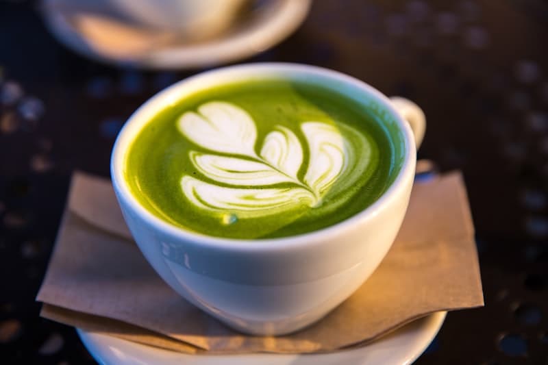 Top-down view of iced matcha with ice cubes and green leaves